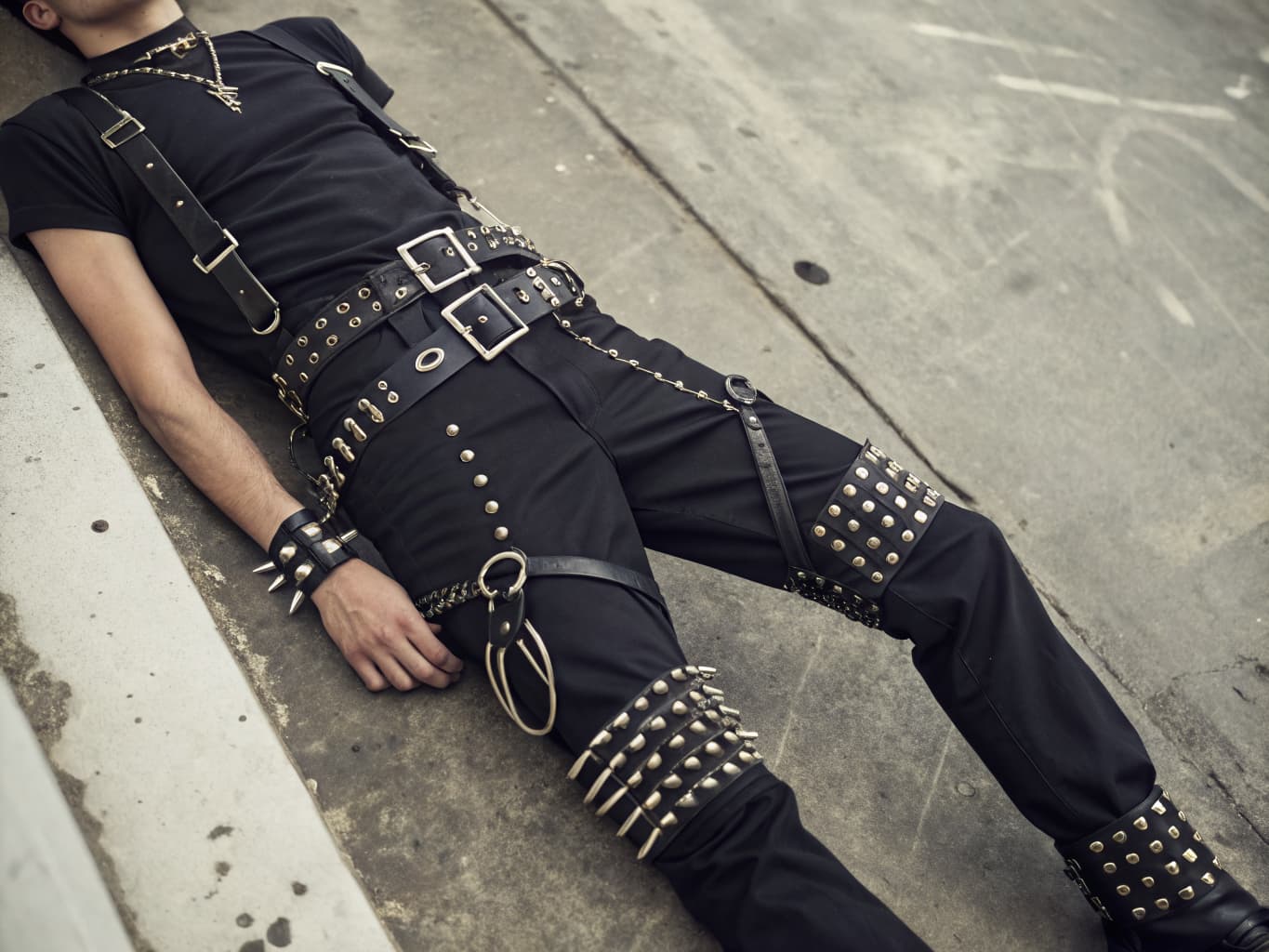 1970s punk style bondage trousers with knee straps, studded belt, and spiked leather cuffs