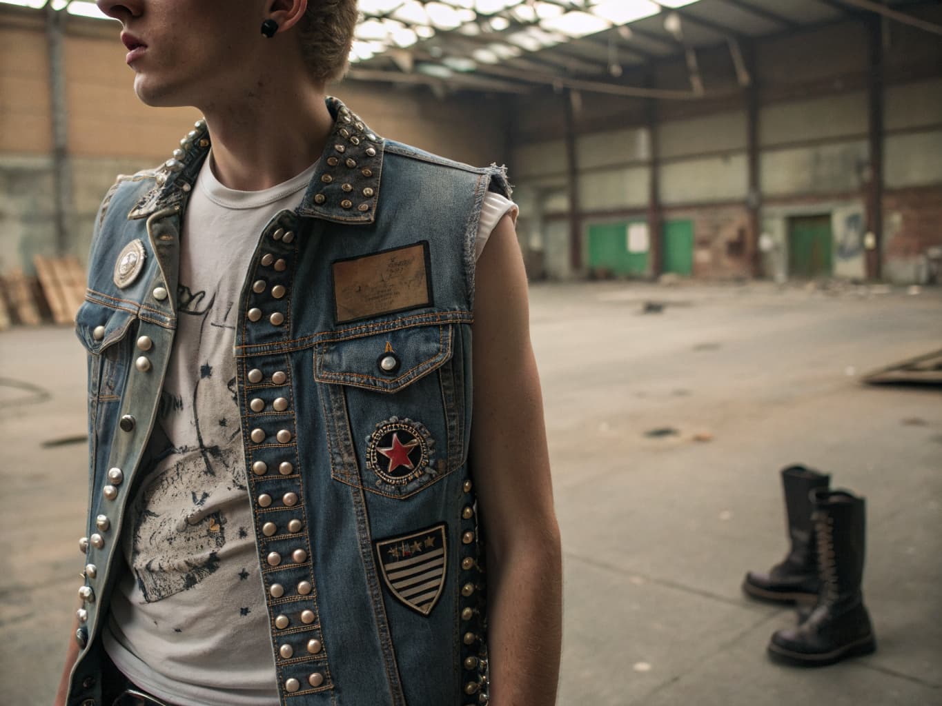 1980s hardcore and crust punk fashion, studded denim vest with patches over combat boots